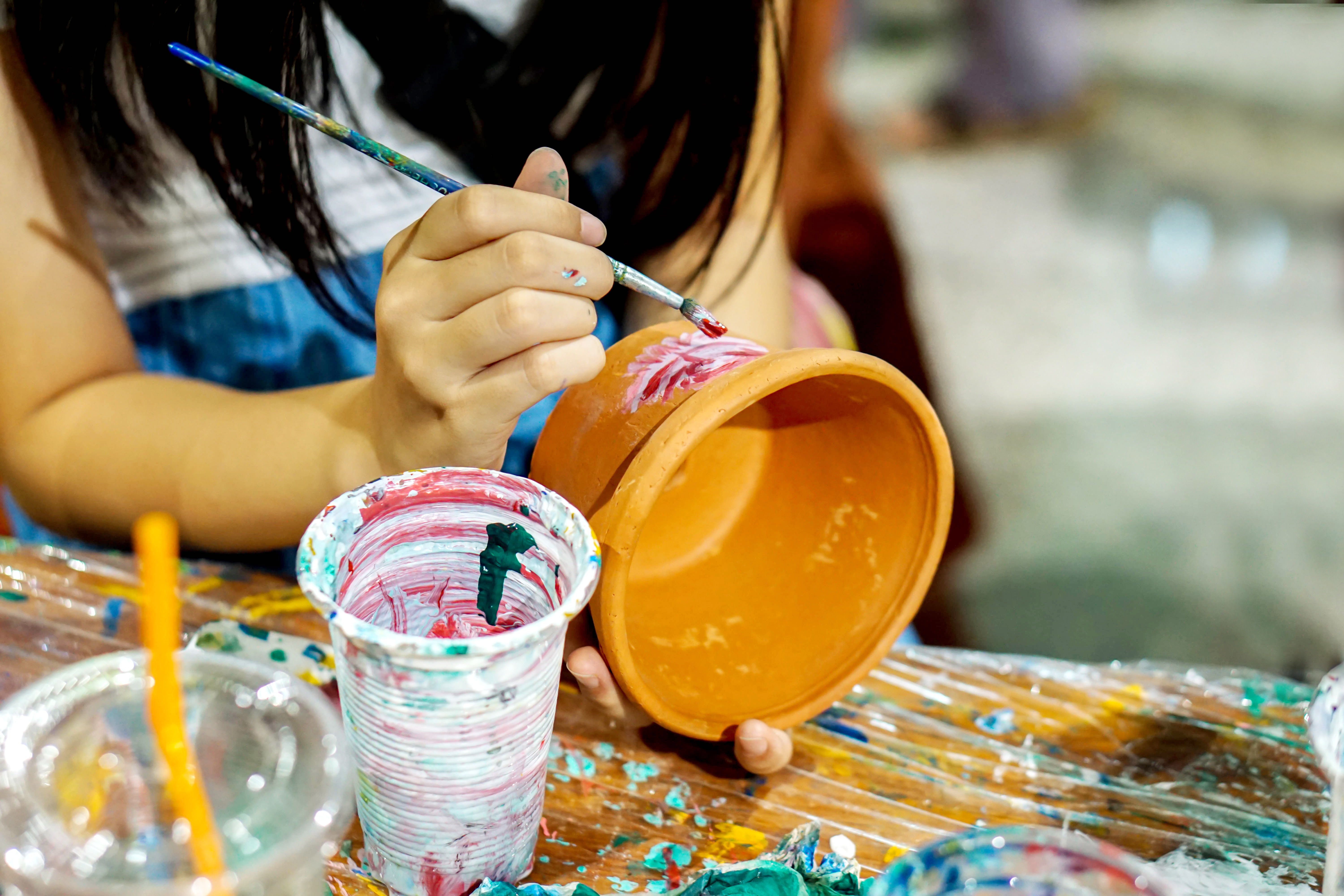 Someone painting a flowerpot.